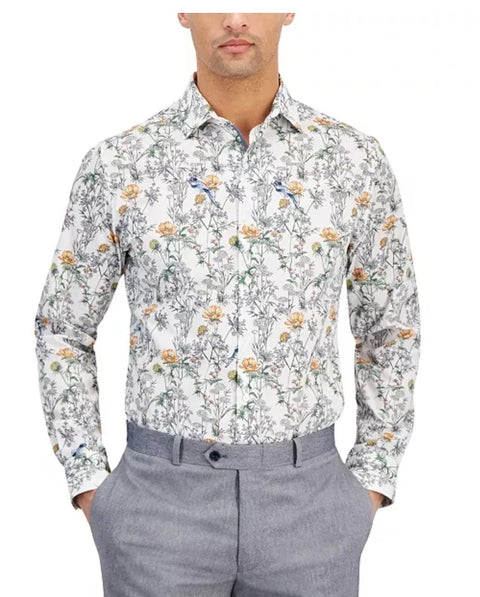 Man wearing a floral patterned shirt and gray pants on a white background