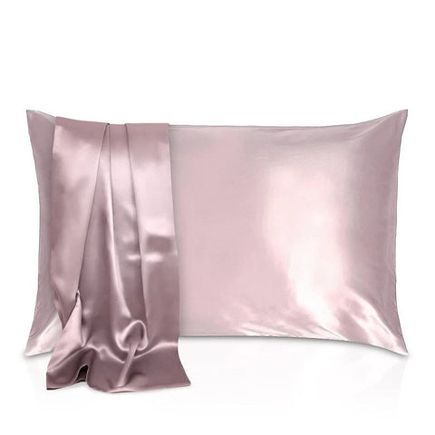 Set of satin pillowcases in various colors with a matching blanket on a white background.
