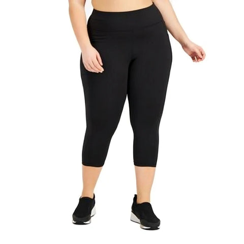 Person wearing black capri leggings on a white background