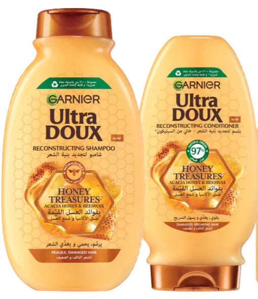 Two bottles of Garnier Ultra Doux Honey Treasures Shampoo and Conditioner, with honey-themed design on the labels.