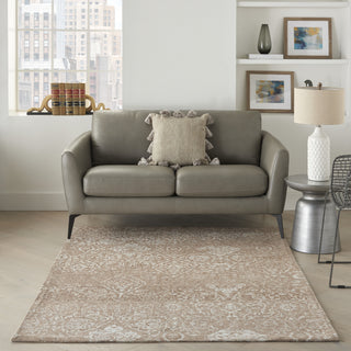 Gray sofa in a living room with a rug and side table.