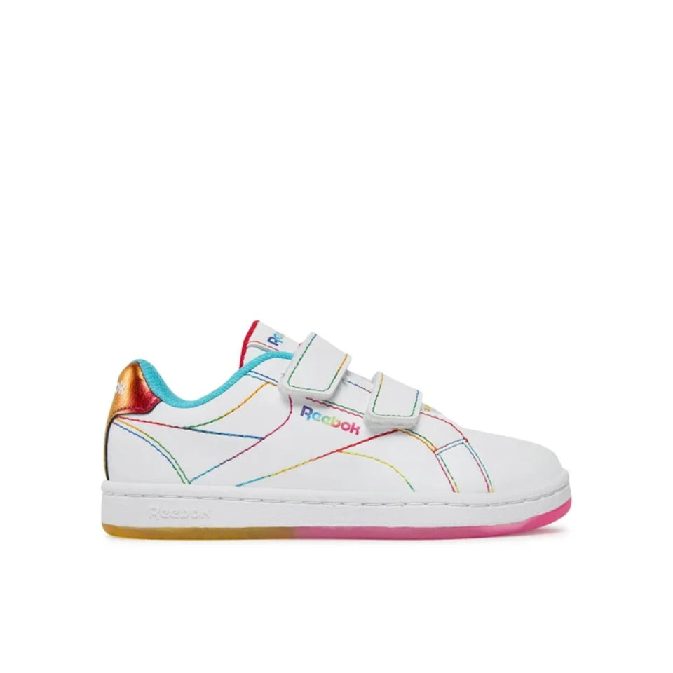 A white Reebok kids' sneaker with colorful rainbow line details, hook-and-loop strap closures, a metallic gold heel tab, and a pink outsole, shown against a plain white background.