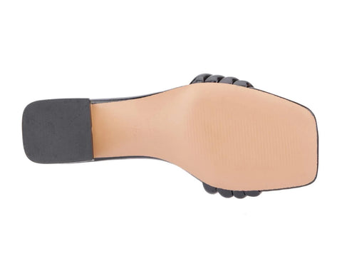 Close-up of a sandal sole with black rubber sole and beige leather upper on a white background