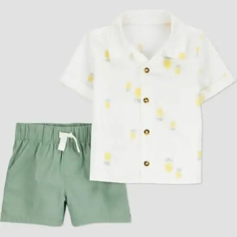White shirt with yellow polka dots and green shorts on a light gray background