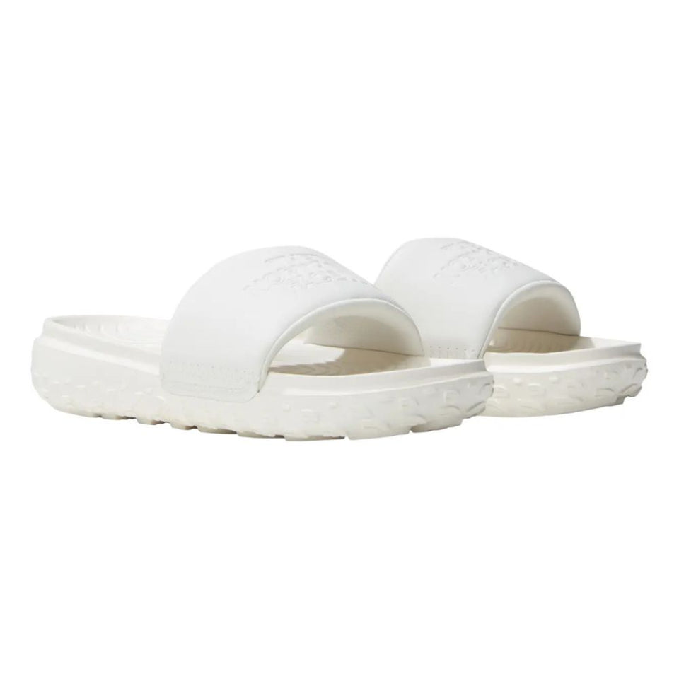 A pair of white slide sandals with embossed branding on the straps and a textured sole, shown against a plain white background.