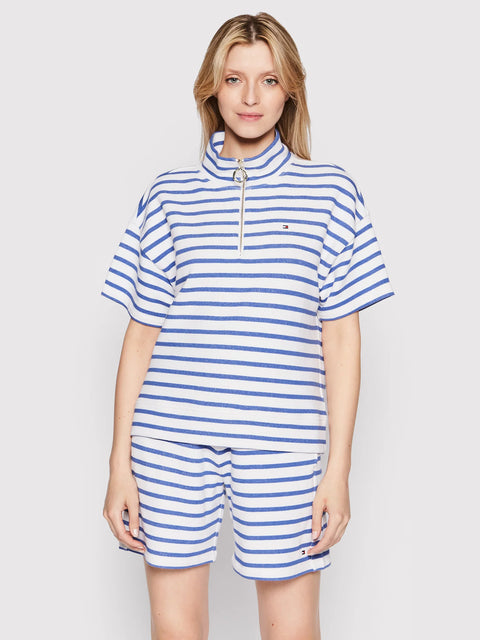 Woman wearing a blue and white striped outfit on a plain background