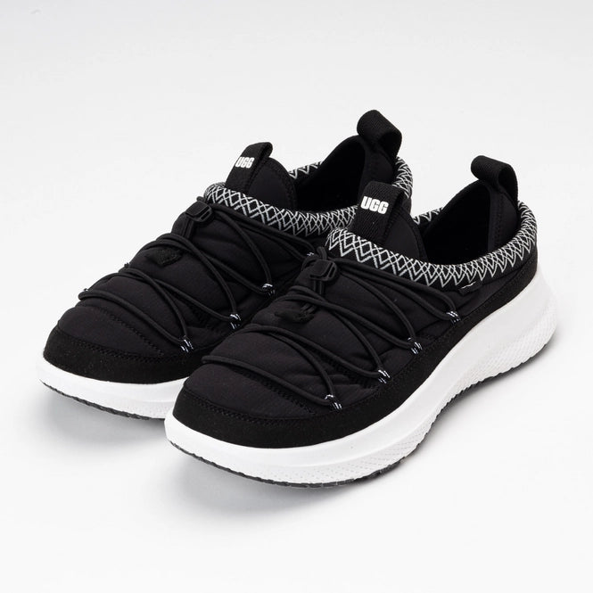Black sneakers with white soles on a light gray background