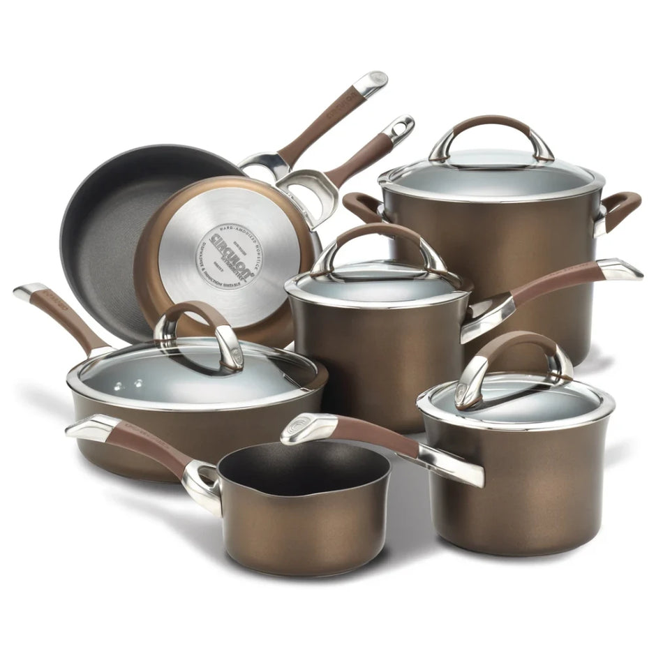 A 12-piece stainless steel cookware set in a bronze finish, including pots, sauté pans, a deep skillet, and lids, arranged on a white background.