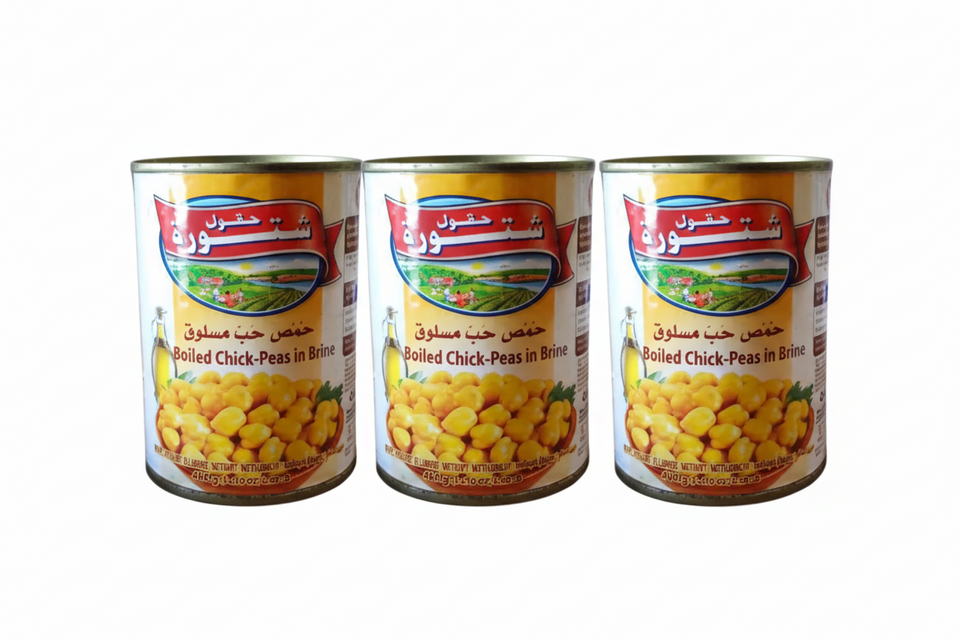 Three cans of Chtoura Fields Boiled Chickpeas in Brine, with product labels in Arabic.