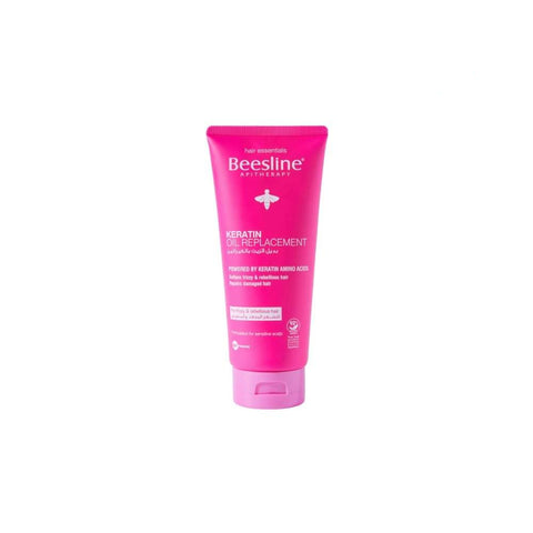 A pink tube of Beesline Keratin Oil Replacement with a white cap, labeled for hair care.